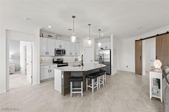11792 Grand Belvedere Way Unit 202, Fort Myers, FL 33913 - kitchen featuring a breakfast bar area, a barn door, a sink, crown molding, and stainless steel appliances