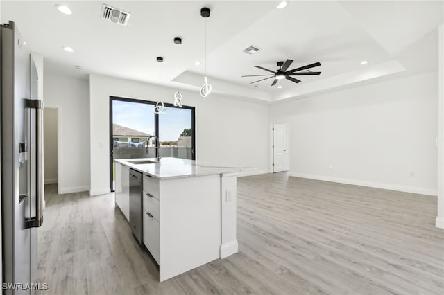 kitchen with a sink, a tray ceiling, visible vents, and recessed lighting