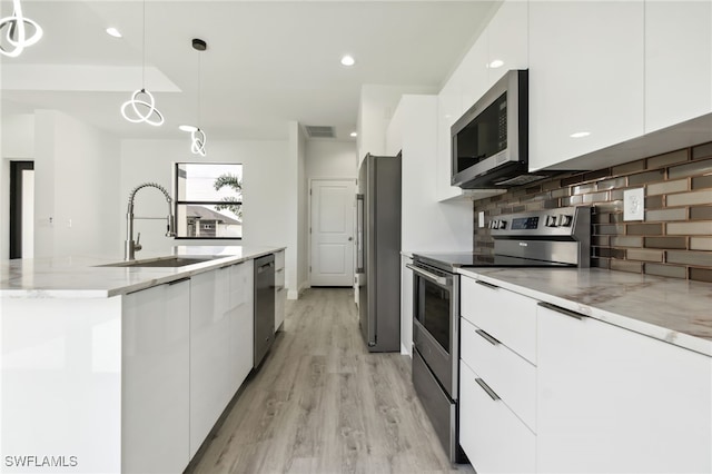 kitchen with a sink, white cabinetry, modern cabinets, and appliances with stainless steel finishes