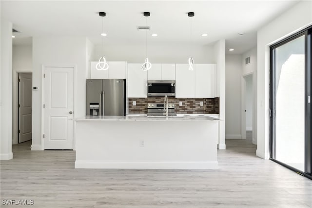 kitchen with light wood finished floors, stainless steel appliances, backsplash, and white cabinets