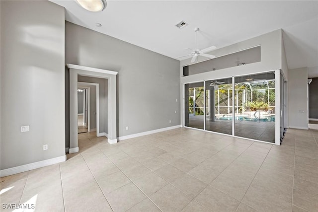 15461 River Cove Ct, North Fort Myers, FL 33917 - empty room with a ceiling fan, baseboards, visible vents, tile patterned floors, and a high ceiling