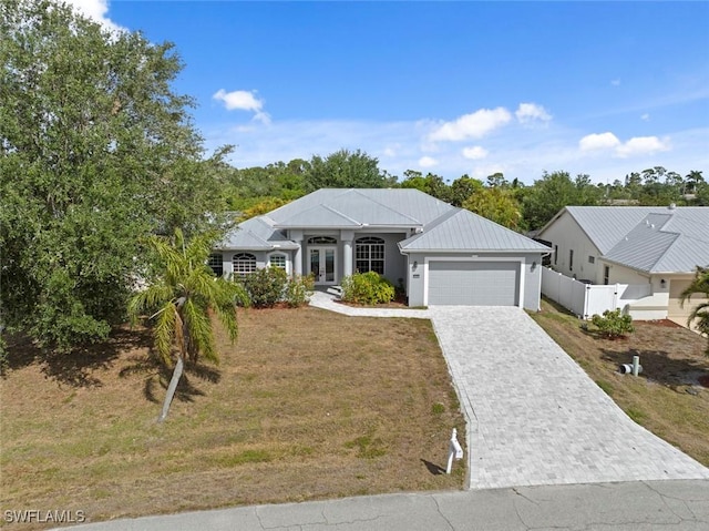 15461 River Cove Ct, North Fort Myers, FL 33917 - view of front of property with fence, french doors, a garage, a front yard, and decorative driveway
