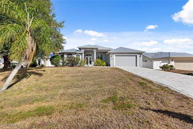 15461 River Cove Ct, North Fort Myers, FL 33917 - prairie-style house featuring french doors, a garage, stucco siding, a front lawn, and decorative driveway