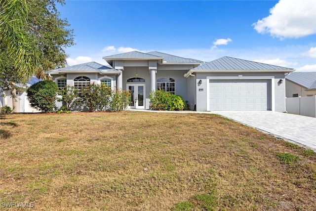 15461 River Cove Ct, North Fort Myers, FL 33917 - view of front of property with a standing seam roof, an attached garage, french doors, and a front yard