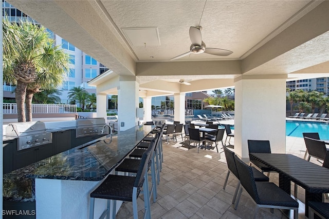 view of patio / terrace featuring a ceiling fan, outdoor dining area, area for grilling, grilling area, and a community pool