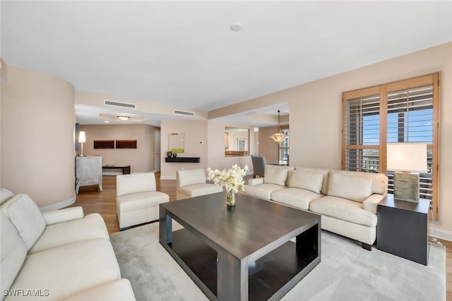 living room featuring visible vents, wood finished floors, and baseboards