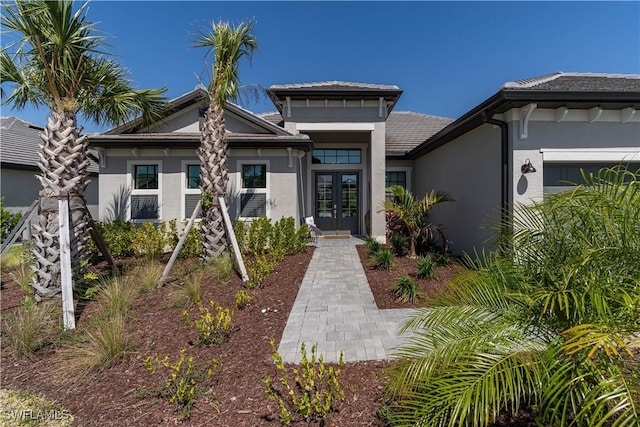 view of front facade featuring stucco siding and french doors
