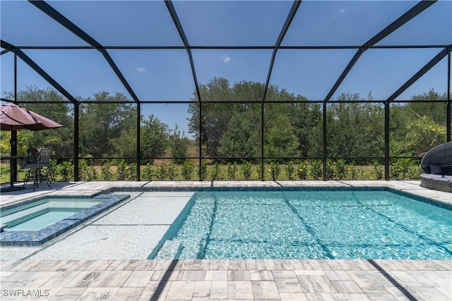 view of pool with a pool with connected hot tub, a patio, and glass enclosure