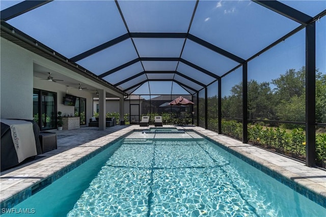 outdoor pool with a patio area, ceiling fan, and glass enclosure