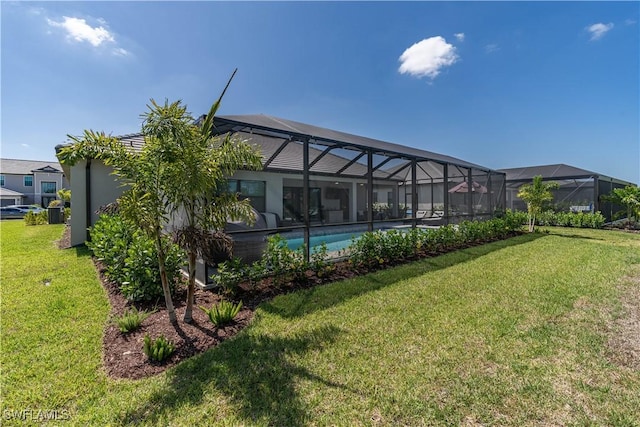 back of property featuring a lanai, an outdoor pool, and a lawn