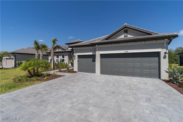 view of front of property featuring a garage, stucco siding, and decorative driveway