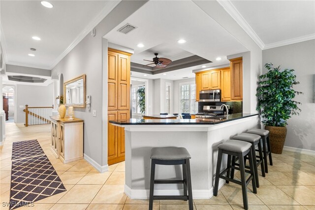 11239 Bienvenida Ct Unit 11C, Fort Myers, FL 33908 - kitchen with appliances with stainless steel finishes, ornamental molding, baseboards, a breakfast bar, and light tile patterned flooring