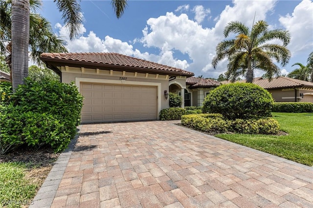 7307 Acorn Way, Naples, FL 34119 - mediterranean / spanish home with decorative driveway, an attached garage, a tiled roof, and stucco siding