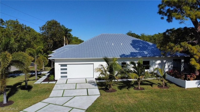 view of front facade featuring driveway, metal roof, an attached garage, stucco siding, and a front yard
