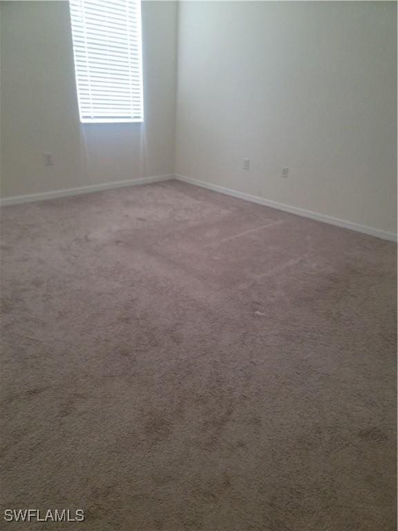 spare room with carpet flooring and baseboards