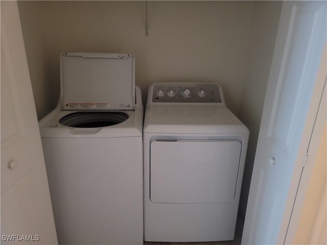 clothes washing area with washing machine and clothes dryer and laundry area