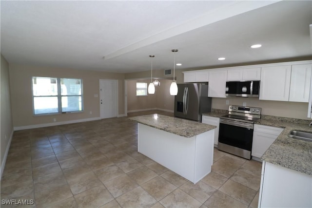4318 S Pacific Cir, North Fort Myers, FL 33903 - kitchen featuring stainless steel appliances, white cabinetry, a kitchen island, and baseboards