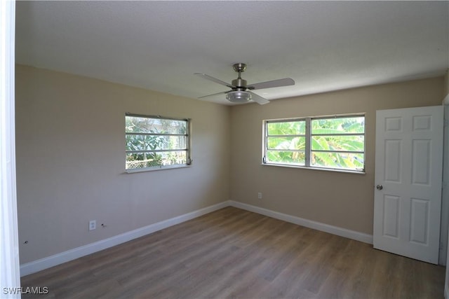 4318 S Pacific Cir, North Fort Myers, FL 33903 - spare room featuring plenty of natural light, wood finished floors, baseboards, and ceiling fan