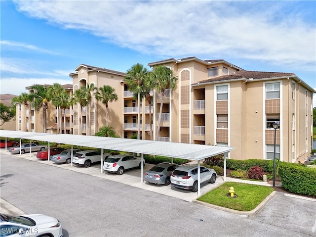 view of apartment building / complex featuring covered parking