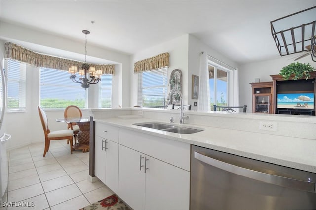 kitchen featuring stainless steel dishwasher, a sink, a chandelier, white cabinetry, and decorative light fixtures