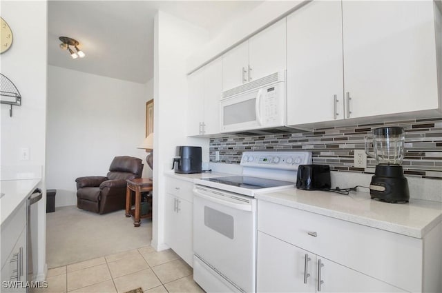 kitchen with white appliances, light colored carpet, white cabinetry, and backsplash