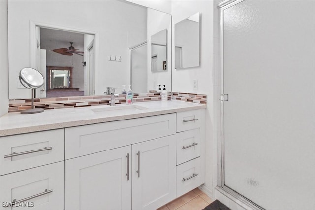 bathroom with decorative backsplash, a shower stall, vanity, and tile patterned flooring