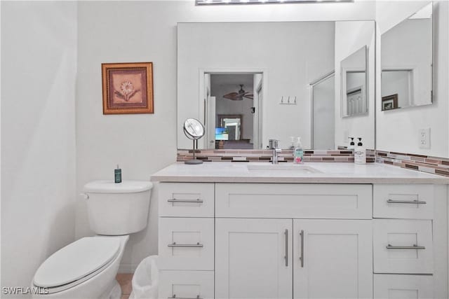 bathroom with tasteful backsplash, toilet, and vanity