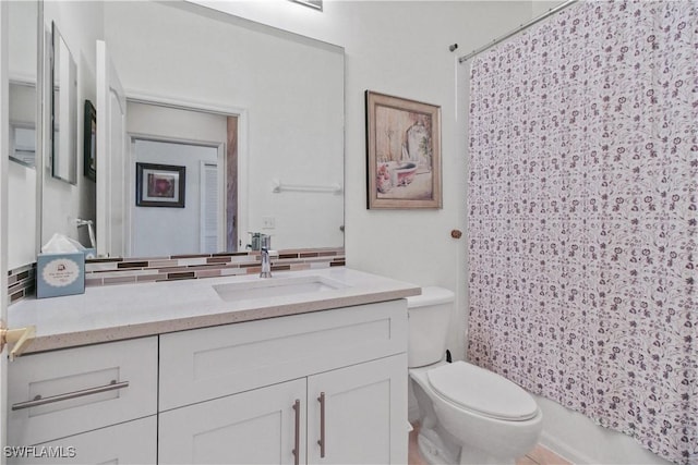 full bathroom featuring toilet, vanity, and backsplash