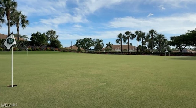 view of property's community featuring an area to practice putting and golf course view