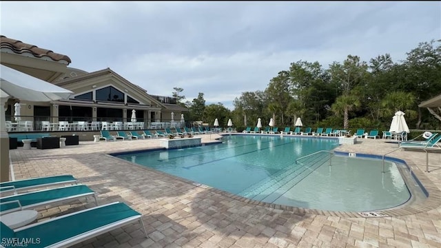 community pool with a patio and fence
