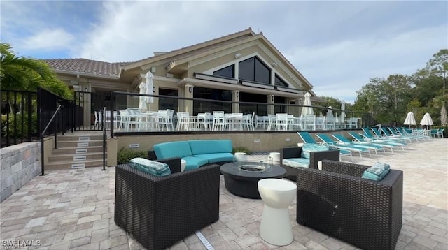 back of property featuring an outdoor living space with a fire pit and a patio area