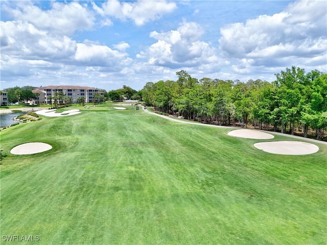 view of property's community featuring golf course view and a yard