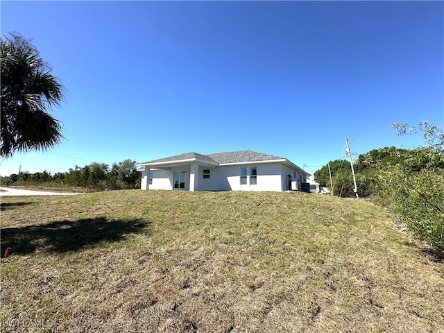 2600 Ida Ct, Lehigh Acres, FL 33971 - view of property exterior with stucco siding and a lawn