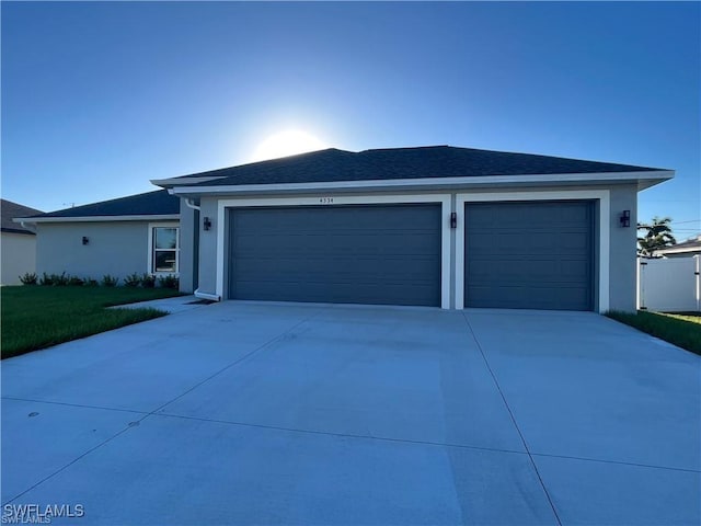4334 SW 9th Pl, Cape Coral, FL 33914 - view of front facade with concrete driveway, a shingled roof, stucco siding, and a garage
