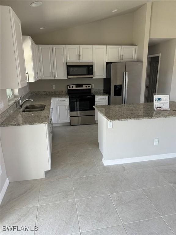 4334 SW 9th Pl, Cape Coral, FL 33914 - kitchen with light stone counters, a sink, vaulted ceiling, white cabinets, and appliances with stainless steel finishes