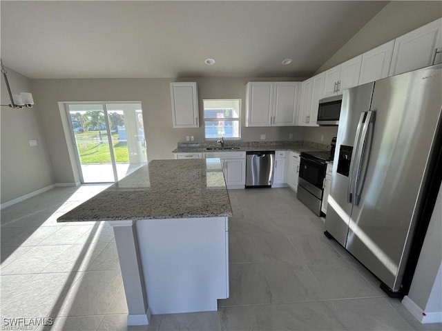 4334 SW 9th Pl, Cape Coral, FL 33914 - kitchen featuring a sink, stainless steel appliances, white cabinetry, a center island, and light stone countertops