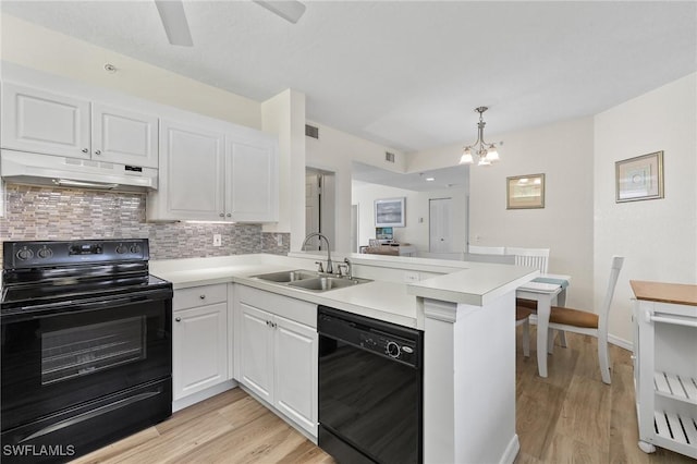22748 Island Pines Way Unit 102, Fort Myers Beach, FL 33931 - kitchen featuring black appliances, a sink, under cabinet range hood, a peninsula, and tasteful backsplash