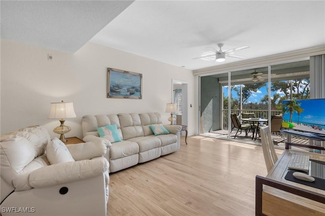 living area with a ceiling fan and light wood-type flooring