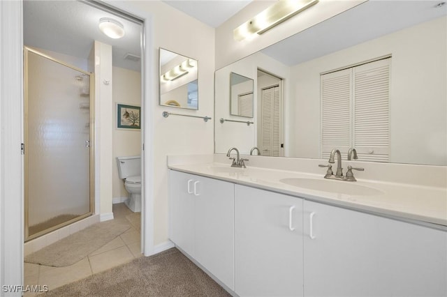 bathroom with toilet, a stall shower, tile patterned flooring, and double vanity