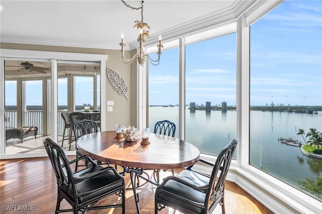 4137 Bay Beach Ln Unit 585, Fort Myers Beach, FL 33931 - dining space with crown molding, a water view, ceiling fan with notable chandelier, and hardwood / wood-style floors