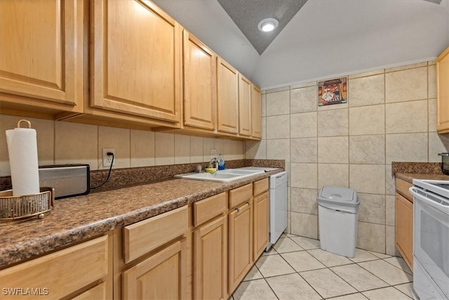 kitchen with white appliances, a sink, light brown cabinets, tile walls, and light tile patterned floors