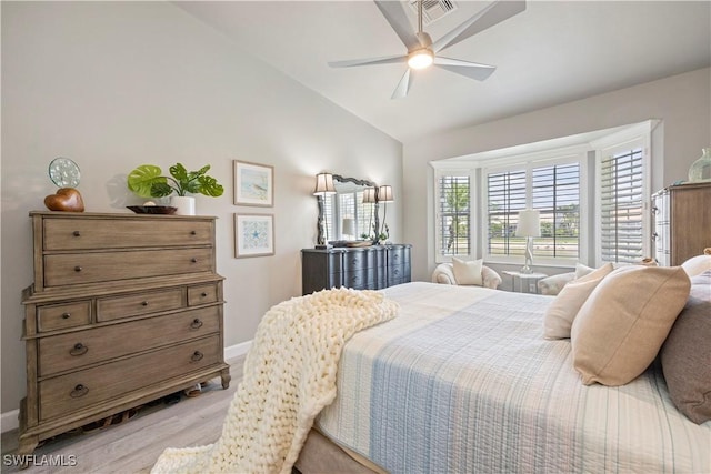 bedroom featuring light wood-style floors, lofted ceiling, baseboards, and a ceiling fan