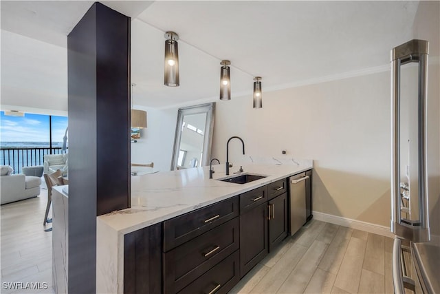 17080 Harbour Point Dr Unit 12B, Fort Myers, FL 33908 - kitchen featuring a sink, appliances with stainless steel finishes, light wood finished floors, a peninsula, and light stone counters