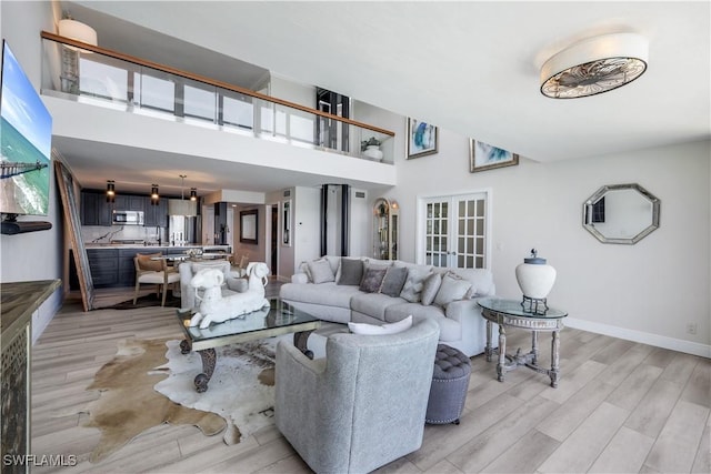 17080 Harbour Point Dr Unit 12B, Fort Myers, FL 33908 - living area featuring light wood-type flooring, a towering ceiling, and baseboards