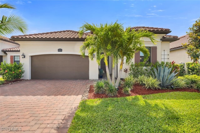 28009 Foxrock Ct, Bonita Springs, FL 34135 - mediterranean / spanish home featuring an attached garage, stucco siding, a tile roof, decorative driveway, and a front yard