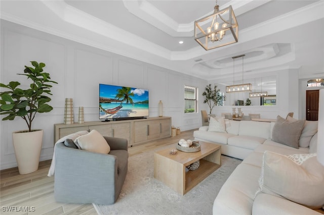 28009 Foxrock Ct, Bonita Springs, FL 34135 - living area featuring an inviting chandelier, light wood-type flooring, a decorative wall, and a raised ceiling
