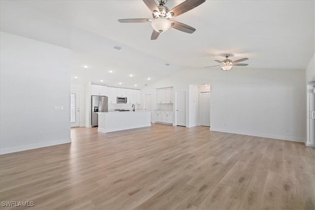 unfurnished living room with light wood finished floors, vaulted ceiling, baseboards, and a ceiling fan
