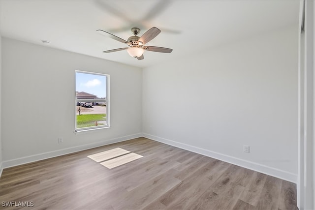 empty room with light wood-style flooring, baseboards, and a ceiling fan