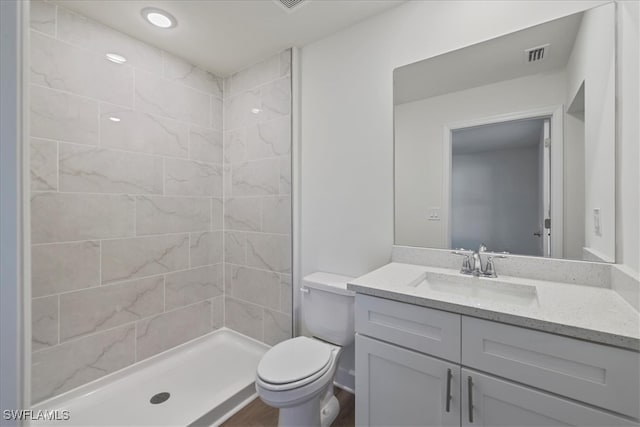 full bath with vanity, toilet, a shower stall, and visible vents