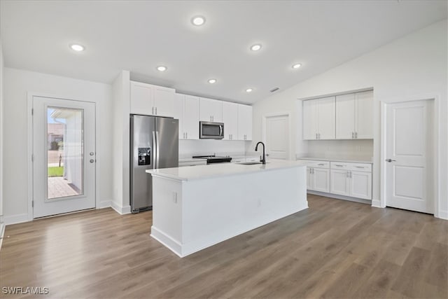 kitchen featuring a sink, white cabinetry, light countertops, appliances with stainless steel finishes, and lofted ceiling